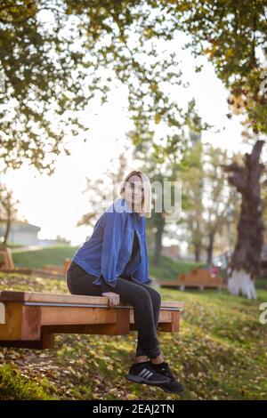 BANJA LUKA, BOSNIA-ERZEGOVINA - 18 ottobre 2017: Ritratto di bionda ragazza in parco indossando sneakers Adidas Foto Stock