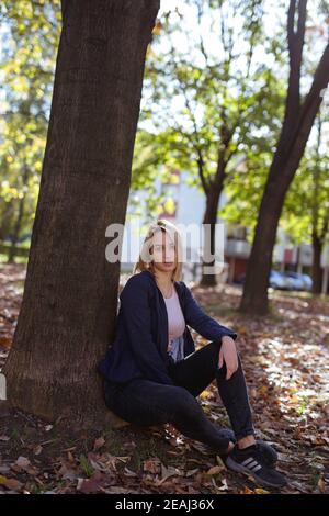 BANJA LUKA, BOSNIA-ERZEGOVINA - 18 ottobre 2017: Ritratto di bionda ragazza in parco indossando sneakers Adidas Foto Stock