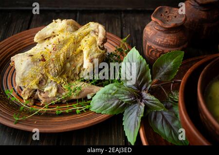 pasto arrosto in pernice su tavola rustica e piatto marrone Foto Stock