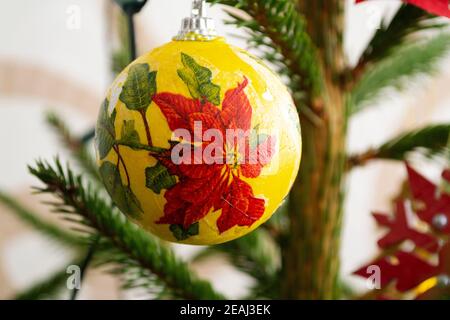 Albero di Natale in ecorations. Composizione anno nuovo con abete rosso. Fiore rosso di natale Poinsettia sulla gioia Foto Stock