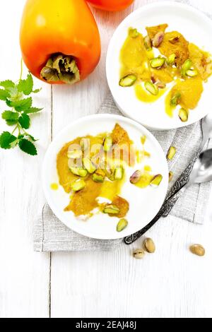 Due ciotole di yogurt e persimmon sulla cima della tavola Foto Stock