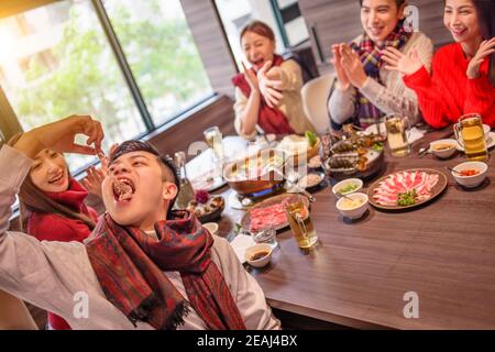 felici i giovani amici che si divertono nel ristorante hot pot Foto Stock