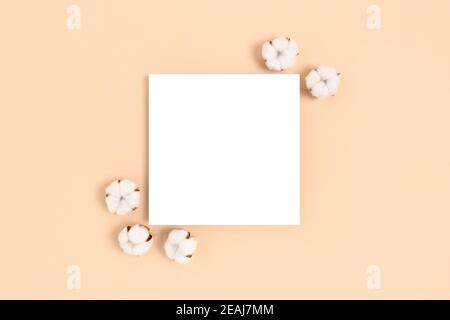 Mockup di carta quadrata con cornice in cotone su sfondo beige. Concetto ecologico. Foto Stock