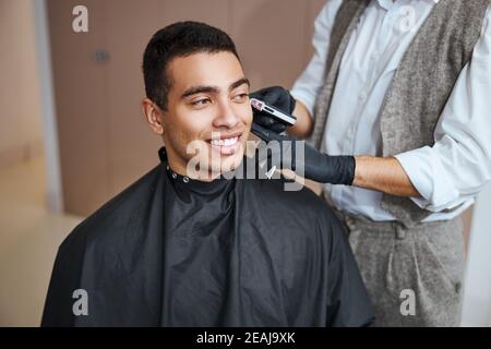 Bell'uomo che si rilassa alla procedura di bellezza nel barbiere Foto Stock