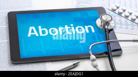 La parola aborto sul display di un tablet Foto Stock