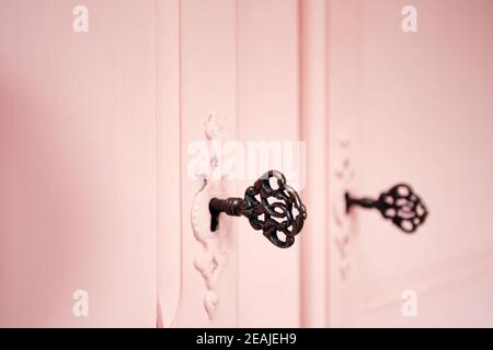 Porte antiche rosa vintage con vecchie chiavi a scheletro in legno a trama di legno di blocco, design retrò Foto Stock