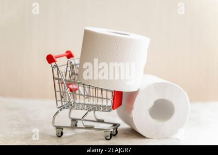 Rotoli di carta igienica primo piano in Mini cart, carrello shopping. Concetto di problema con i beni essenziali di consumo, igiene, salute Foto Stock