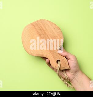 donna mano che tiene in mano un asse di legno rotondo vuoto Foto Stock