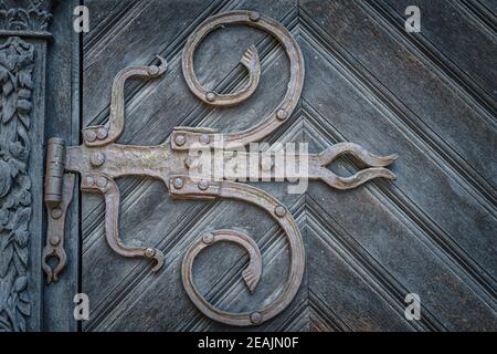 Primo piano su cerniere in ferro d'epoca in stile barocco su legno porta Foto Stock