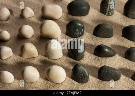 Pietre che si stagliano dalla sabbia alla luce del sole Foto Stock