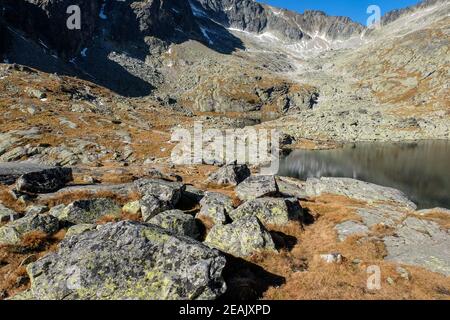 Stagno in Valle di cinque laghi di Spide circondato da cime rocciose, alti Monti Tatra, Slovacchia. Foto Stock