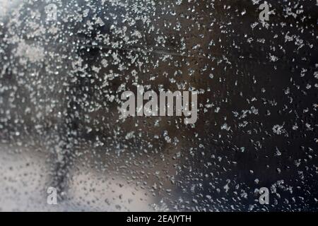 Neve sul finestrino dell'auto durante l'inverno - neve fresca e acqua Foto Stock