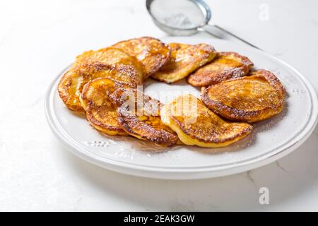 Frittelle fatte in casa a basso contenuto di calari al formaggio cagliato su piatto bianco Foto Stock