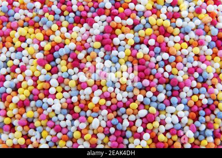 centinaia e migliaia spruzzano le piccole perle di zucchero per decorare le torte e dessert texture di sfondo Foto Stock