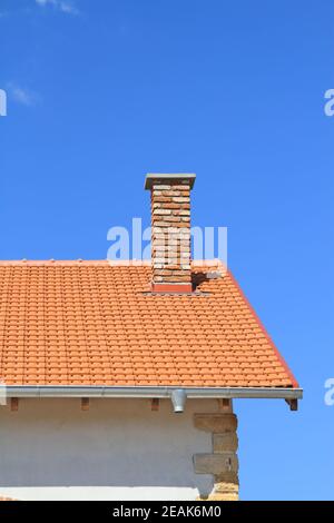 Il nuovo tetto e camino sotto il cielo blu Foto Stock