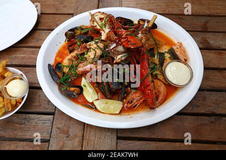 Piatto di pesce alla griglia su tavolo di legno Foto Stock