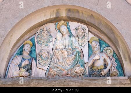 Vergine Maria con Gesù Bambino e Santi sul portale della chiesa di San Giuseppe a Lucca, Italia Foto Stock