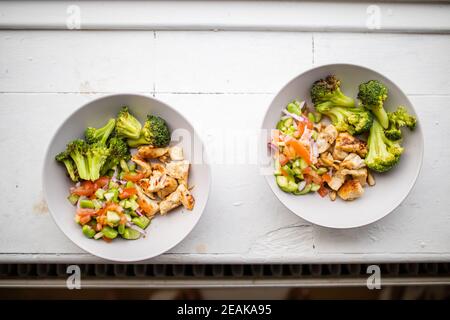Broccoli e insalate di pollo dall'alto sul bancone bianco Foto Stock
