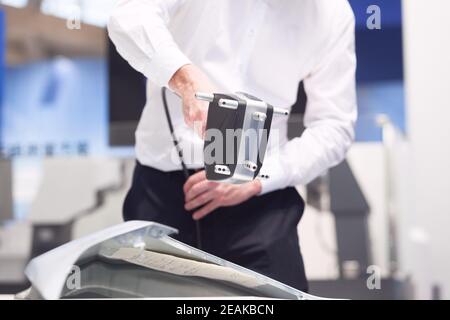 Tecnico di metrologia che esegue controlli di qualità o ispezioni con professionisti portatili Scanner laser 3D Foto Stock