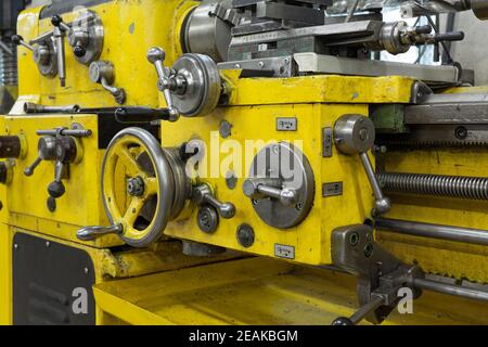 Vecchio tornio giallo con molte maniglie. Foto Stock