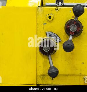 Vecchio tornio giallo con molte maniglie. Foto Stock