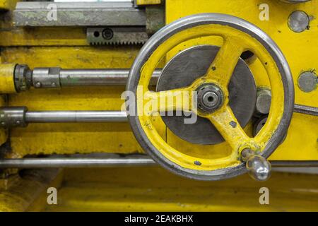 Vecchio tornio giallo con molte maniglie. Foto Stock