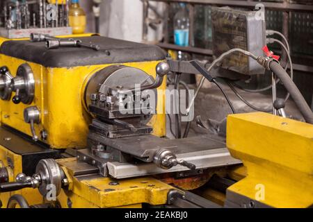 Vecchio tornio giallo con molte maniglie. Foto Stock