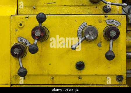 Vecchio tornio giallo con molte maniglie. Foto Stock