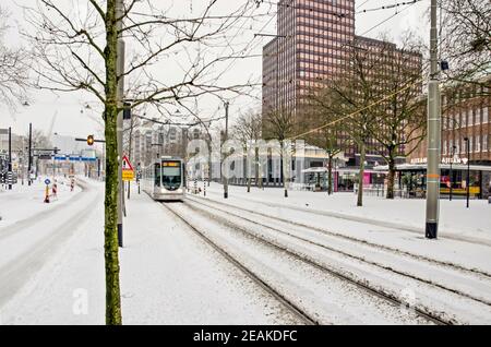 Rotterdam, Paesi Bassi, 7 febbraio 2021: Tram in pista su un viale Coolsingel innevato in una giornata fredda in inverno Foto Stock