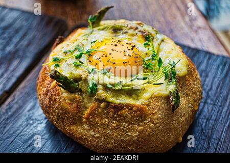 Pane ripieno vegetariano appena sfornato con pomodori a cottura lenta, spinaci, porri, funghi ostrici, avocado, e asparagi, ricoperti di c. fuso Foto Stock