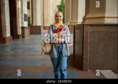 Studente arabo con libri all'ingresso dell'università Foto Stock