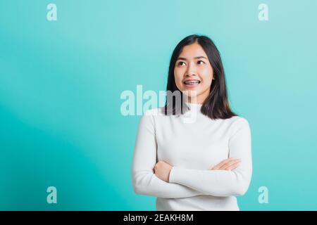 donna sorridente con braccia incrociate Foto Stock