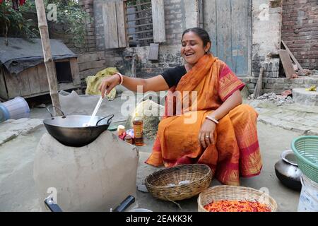 Il modo tradizionale di fare cibo sul fuoco aperto nella vecchia cucina in un villaggio, Kumrokhali, West Bengal, India Foto Stock