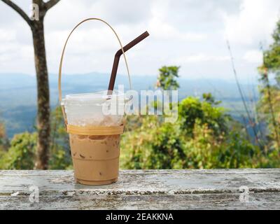 Un bicchiere di tè tailandese su uno sfondo di montagna Parco Nazionale di Khao Yai Foto Stock