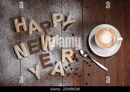 L'iscrizione Happy New Year-cookies sotto forma di lettere in pasta di zenzero. Biscotti allo zenzero, concetto di anno nuovo . Lavoro fatto a mano. La stampa è come uno stencil. Foto Stock