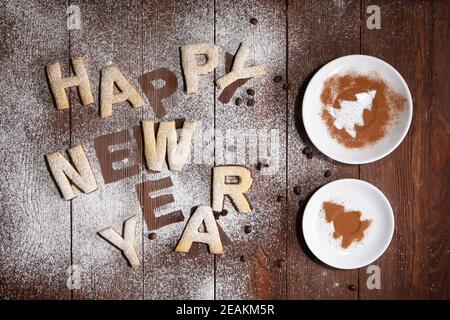 L'iscrizione Happy New Year-cookies sotto forma di lettere in pasta di zenzero. Biscotti allo zenzero, concetto di anno nuovo . Lavoro fatto a mano. La stampa è come uno stencil. Foto Stock