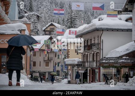 Cortina d'Ampezzo, Italia. 10 febbraio 2021, Italia, Cortina d'Ampezzo: Sci alpino, Coppa del mondo: I pedoni sono in movimento nel centro di Cortina. Dopo una forte nevicata, la giornata di gara è stata completamente annullata. La stazione sciistica è la sede delle Olimpiadi invernali 2026 che si terranno a Milano e Cortina d'Ampezzo. Foto: Michael Kappeler/dpa Credit: dpa Picture Alliance/Alamy Live News Foto Stock