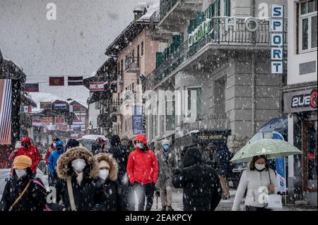 Cortina d'Ampezzo, Italia. 10 febbraio 2021, Italia, Cortina d'Ampezzo: Sci alpino, Coppa del mondo: I pedoni sono in movimento nel centro di Cortina. Dopo una forte nevicata, la giornata di gara è stata completamente annullata. La stazione sciistica è la sede delle Olimpiadi invernali 2026 che si terranno a Milano e Cortina d'Ampezzo. Foto: Michael Kappeler/dpa Credit: dpa Picture Alliance/Alamy Live News Foto Stock