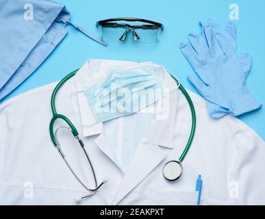 cappuccio in tessuto, abito medico bianco, maschera monouso e occhiali protettivi in plastica Foto Stock