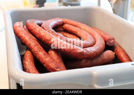 Bobine di salsiccia finita in vasche per la lavorazione della carne Foto Stock