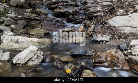 Primo piano i flussi di fiume di montagna tra le pittoresche pietre estive. Rocce in montagna con acqua che scorre Foto Stock