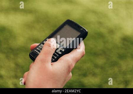 La ragazza tiene un vecchio telefono a bottone in mano Foto Stock