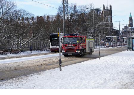 Edimburgo, Scozia, Regno Unito. 10 febbraio 2021. Una notte di nevicata pesante nel centro della città lascia Princes Street coperta di neve. Fire Engine accelera lungo una strada innevata di Princes. Credit: Craig Brown/Alamy Live News Foto Stock