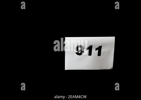 Chiamata 911 e concetto di chiamata di emergenza, testo 911 su carta isolata in nero. Foto Stock