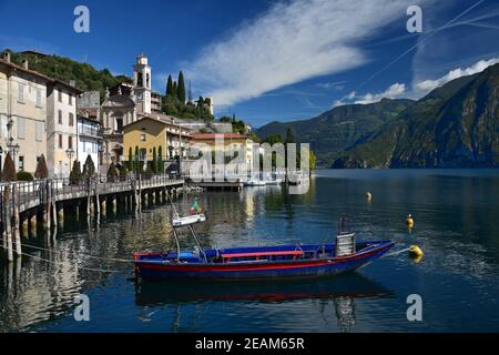 La cittadina di Riva di Solto sul Lago d'Iseo, Lombardia, Italia. Una barca di fronte. Foto Stock