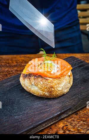 Pani di pane pieni di salmone affumicato, crème fraiche, spinaci, pomodoro a tostatura lenta, porri e formaggio. Foto Stock
