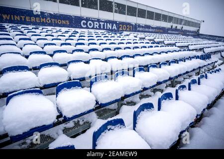 10 febbraio 2021, Italia, Cortina d'Ampezzo: Sci alpino: Coppa del mondo: La neve giace sulla tribuna vuota dei Campionati Mondiali di Sci. Dopo una forte nevicata, la giornata di gara è stata completamente annullata. La stazione sciistica è la sede delle Olimpiadi invernali 2026 che si terranno a Milano e Cortina d'Ampezzo. Foto: Michael Kappeler/dpa Foto Stock