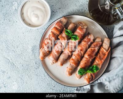 Salsicce avvolto in pancetta Foto Stock