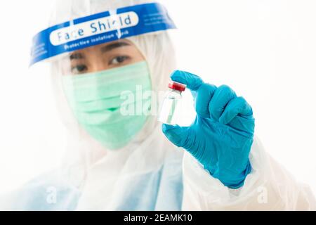 Scienziato medico femminile in uniforme PPE che indossa una maschera facciale protezione Foto Stock