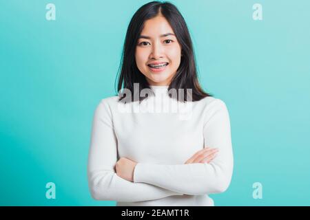 donna sorridente con braccia incrociate Foto Stock